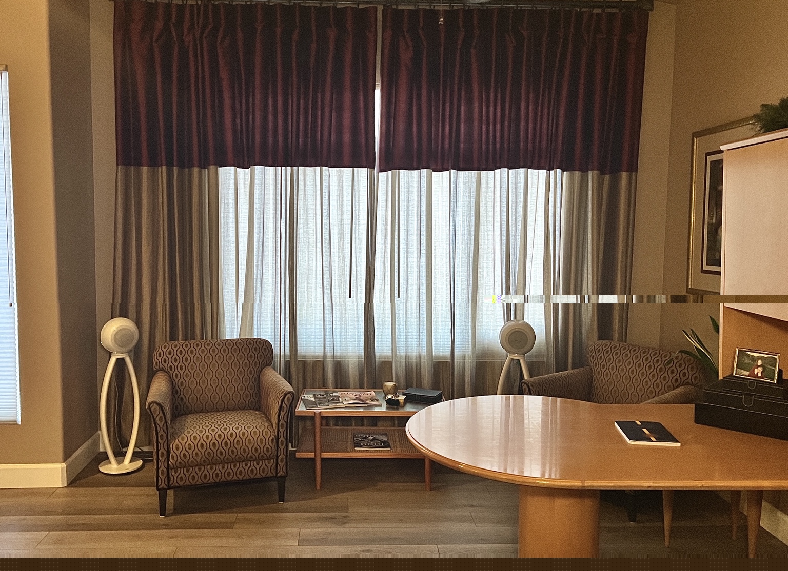 A pair of white Cabasse Pearl Akoya speakers on stands in Loren Roetman’s home office